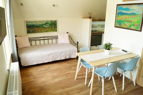 a small room with a bed and a table and chairs at Apartmány u komína in Terezín