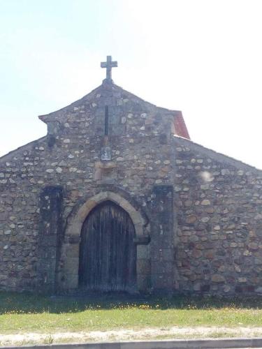 an old stone church with a wooden door and a cross at Casa da Lomba in Arganil