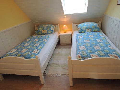 two twin beds in a small room with a window at Goden Wind 4 in Westerdeichstrich