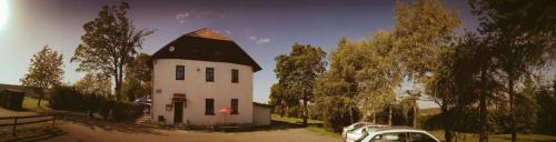 a small white house with a black roof at Penzion Vozzýk in Nové Hutě