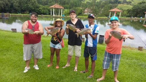 a group of young people holding their baseball equipment at Pousada & Pesca Esportiva Fazolin in Socorro