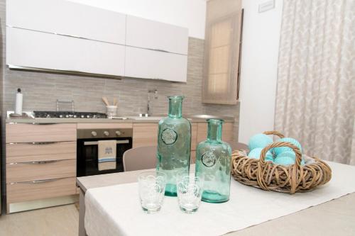 two bottles and glasses on a table in a kitchen at Casa Vacanze Fontana in San Vito lo Capo