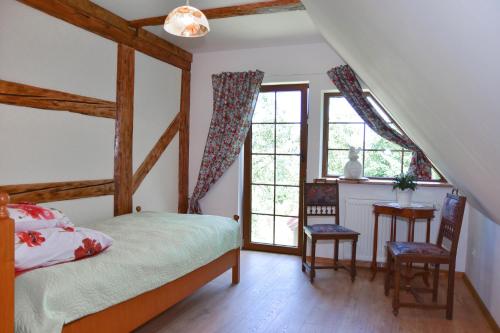 Un dormitorio con una cama y una mesa y sillas. en Wilcza Gajowka, en Sosnówka