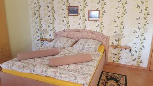 - une chambre avec un lit rose et 2 oreillers dans l'établissement Ferienwohnung "Am Fechtertor- Eingang zum Schlosspark", à Putbus