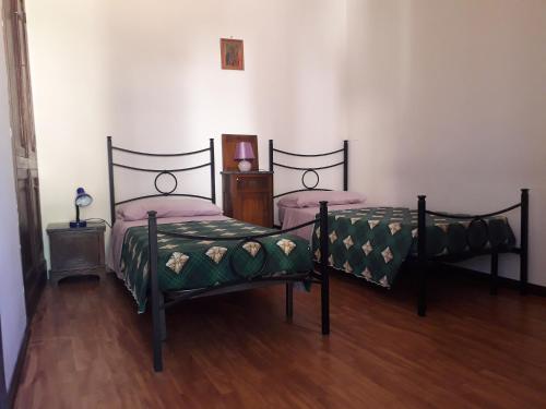 two twin beds in a room with wooden floors at Nonna Bruna in Rieti