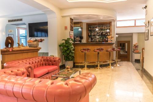 un bar con 2 sofás de cuero y una barra de bar en Hotel Gardenia Sorrento, en Sorrento