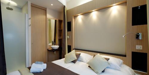 - une chambre avec un grand lit blanc et des oreillers blancs dans l'établissement Castel Victoria, à Le Touquet-Paris-Plage