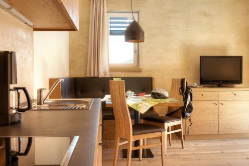 a kitchen with a table and a dining room at Residence Sägemühle in Prato allo Stelvio