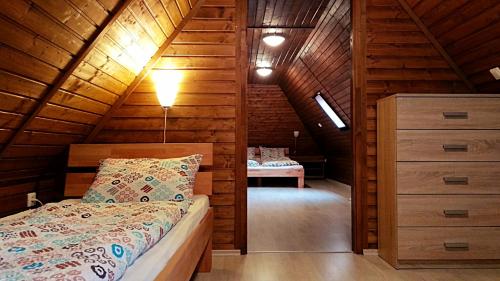 ein Schlafzimmer mit einem Bett in einer Holzhütte in der Unterkunft Villa Teleki in Teleki