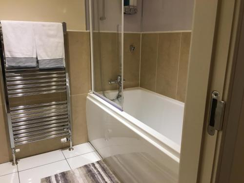 Das Bad ist mit einer Badewanne mit einer Dusche ausgestattet. in der Unterkunft Marina View Apartment in Inverkip