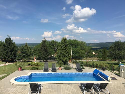 a large swimming pool with chairs and a blue poolvisor at Villa Teleki in Teleki