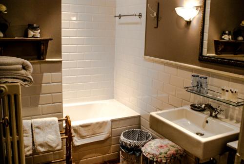 een badkamer met een wastafel en een bad bij Guest House Huyze Die Maene in Brugge