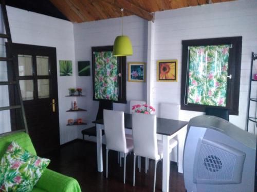 a dining room with a table and chairs and a tv at El mirador del consuelo in Jorquera