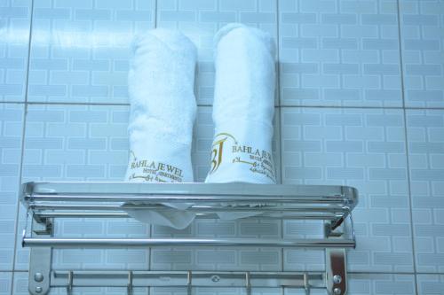 wieszak na ręczniki z 2 rolkami papieru toaletowego w łazience w obiekcie Bahla Jewel Hotel Apartments w mieście Bahlāʼ