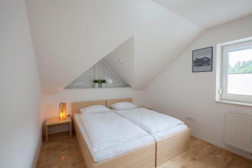 a white bedroom with a bed and a window at Luxury apartment Karolina in Bled