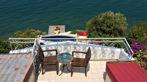 a balcony with a table and chairs and a boat at Ece Hotel Sovalye Island in Fethiye