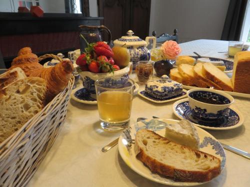 - une table de petit-déjeuner avec du pain, des fruits et du jus d'orange dans l'établissement Chambres d'Hôtes L’Échappée Belle, à Saint-Brisson-sur-Loire