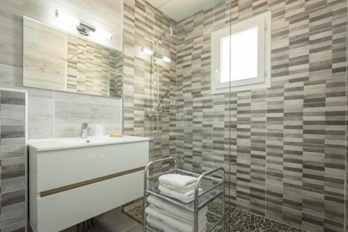 bagno con lavandino e doccia di Hôtel Le Saint-Geniès a Uzès