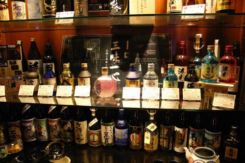 a shelf filled with lots of bottles of alcohol at Hotel Gasthof in Kagoshima