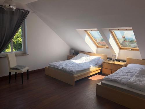 a attic bedroom with two beds and two windows at Panorama Apartament Sopot in Sopot