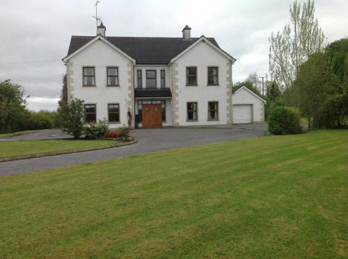 a large white house with a large yard at The White House in Enniskillen