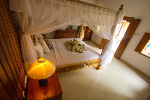 einen Blick über ein Schlafzimmer mit einem Himmelbett in der Unterkunft Hotel Shri Ganesh in Lovina