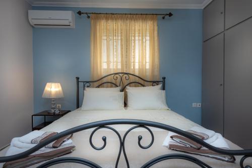 a bedroom with a large bed with a blue wall at Erato Apartment in Tsilivi
