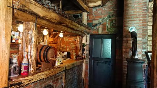 a bar with a brick wall and a black door at Satul Traditional in Runcu