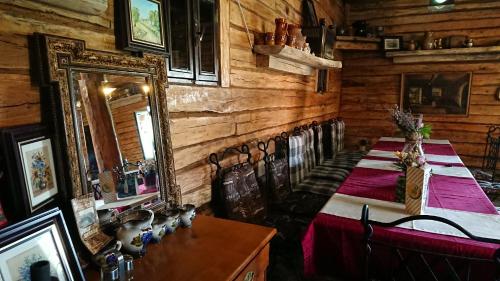 a dining room with a table and a mirror at Satul Traditional in Runcu