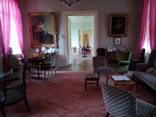 a living room with a table and chairs at Chambres d'hôtes & Gîtes du Château de Grand Rullecourt in Grand Rullecourt