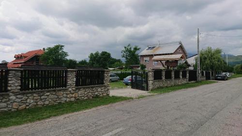 a stone fence on the side of a road next to a house at Satul Traditional in Runcu