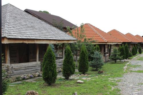 a row of houses with trees in front of them at Satul Traditional in Runcu