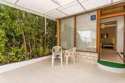 - deux chaises sur la terrasse couverte avant d'un bâtiment dans l'établissement Studio Leon-Sara, à Split