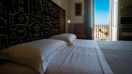 a bedroom with two beds and a window with a view at L'Incanto Luxury Rooms in Matera