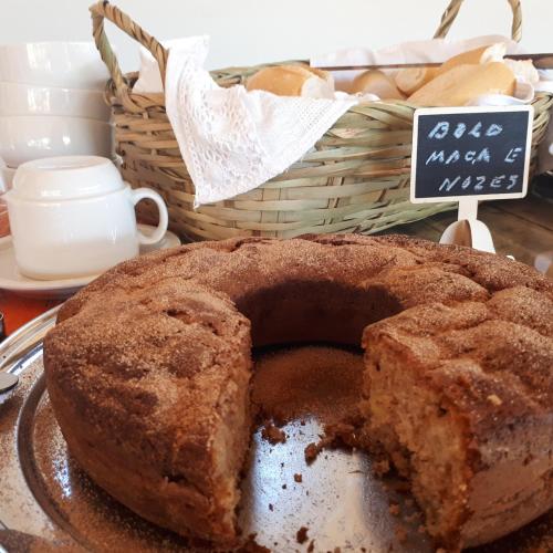 Un plato con un pastel y una cesta de pan. en Chácara Leolud, en Socorro