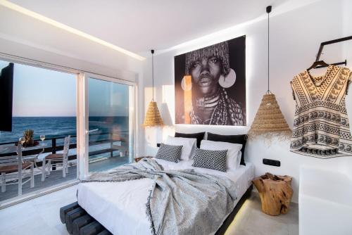 Portara Seaside Luxury Suites في ناكسوس تشورا: غرفة نوم بسرير مع صورة كبيرة على الحائط