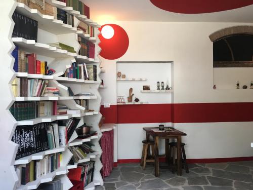 a wall of bookshelves in a room with a table at Villa Baronzola in Montevarchi