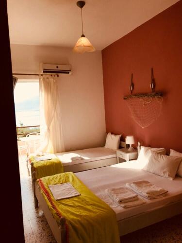 a bedroom with two beds and a window with a view at Apartments Skardoutsou in Agiokampos