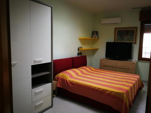 Schlafzimmer mit einem Bett und einem TV in der Unterkunft Mira in Alghero
