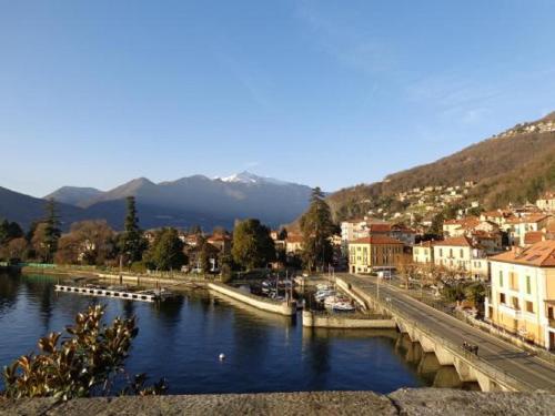 a city with a river and buildings and a mountain at The Camp by Maggiore Suites in Maccagno Inferiore