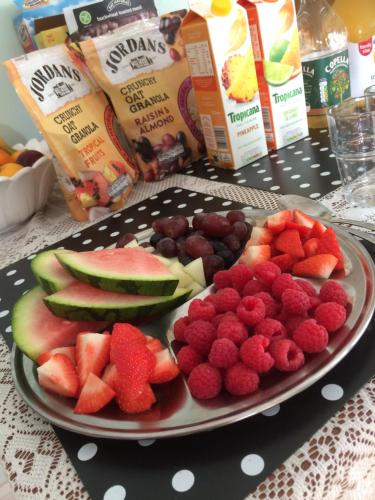 a plate of fruit and berries on a table at Jonti Bed And Breakfast in Corfe Castle