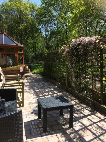 a patio with a bench and a table and a fence at Jonti Bed And Breakfast in Corfe Castle