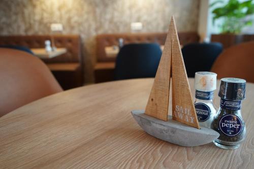 a wooden boat on a table with two cups of beer at Aquarius Hotel in Scheveningen