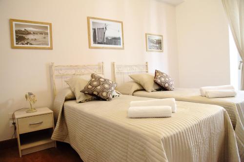 two beds sitting next to each other in a room at B&B Evelyne in Taormina