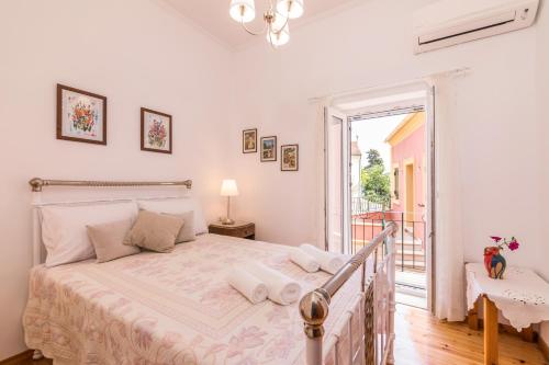 1 dormitorio con 1 cama grande y balcón en Milena's Country House, en Pelekas