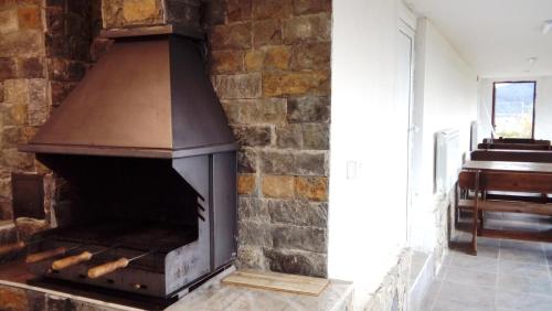 a brick fireplace in a room with a piano at Vila Lidia in Tsigov Chark