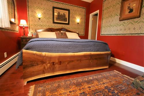 a bedroom with a wooden bed in a red room at Alpenhof Bed & Breakfast in Media