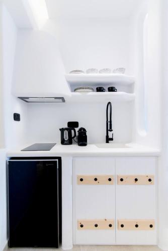 a kitchen with a sink and a black dishwasher at Portara Seaside Luxury Suites in Naxos Chora