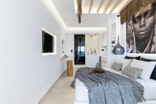 a living room with a white couch and a painting on the wall at Portara Seaside Luxury Suites in Naxos Chora