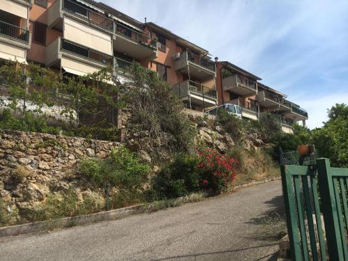 an apartment building on a hill next to a road at argentario home in Porto Santo Stefano
